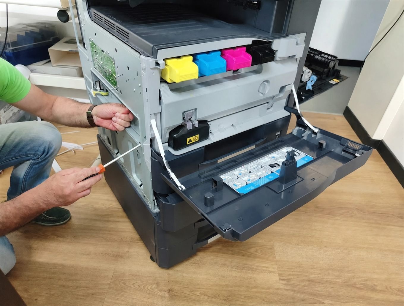 Técnico da IMPRESS fazendo manutenção em uma impressora multifuncional